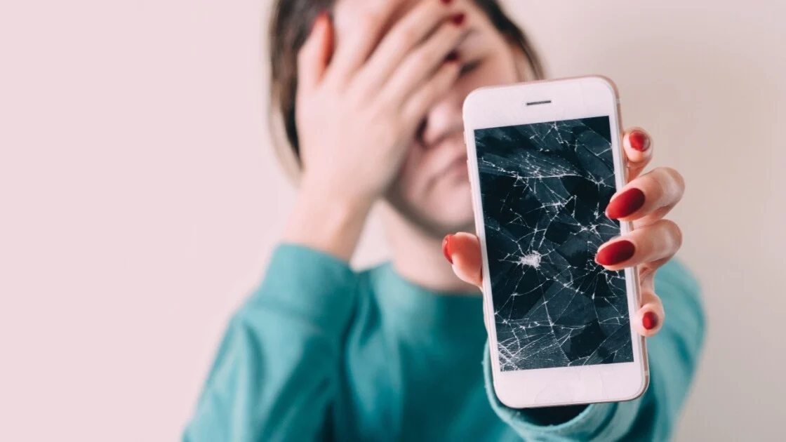 Smartphone screen showing cracks and scratches caused by everyday habits, with repair tools nearby.